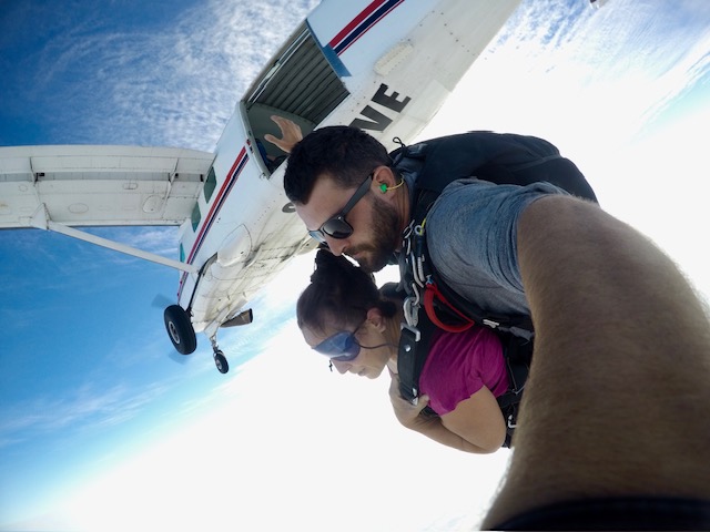 The moment Cory McNabb jump out of a plane while skydiving, strapped to a guide who is taking the photo.
