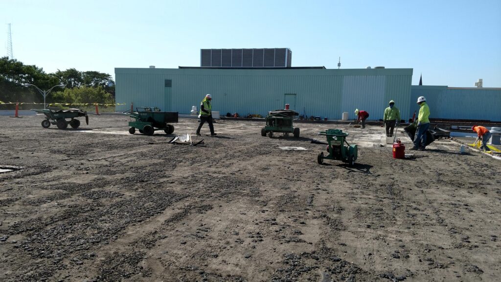 Demolition underway on the roof of an industrial manufacturing facility